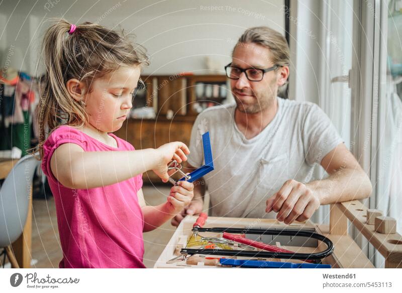 Father looking at daughter working with tools father pa fathers daddy dads papa Tool Kit daughters learning parents family families people persons human being