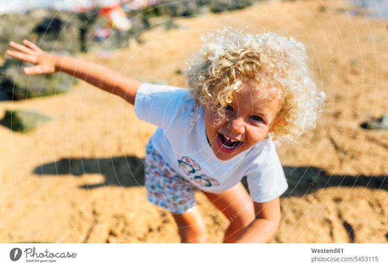 Portrait of laughing little boy on the beach beaches boys males portrait portraits child children kid kids people persons human being humans human beings