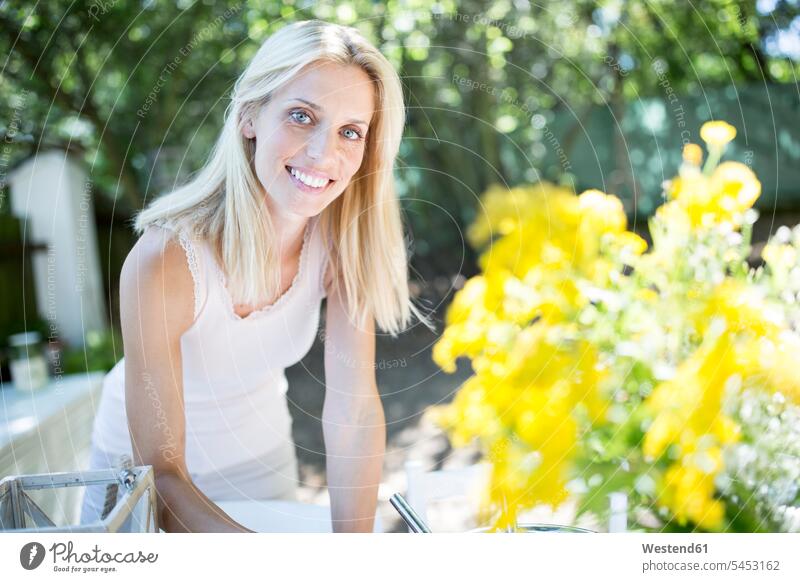 Smiling woman with flowers outdoors smiling smile females women Flower Flowers Adults grown-ups grownups adult people persons human being humans human beings