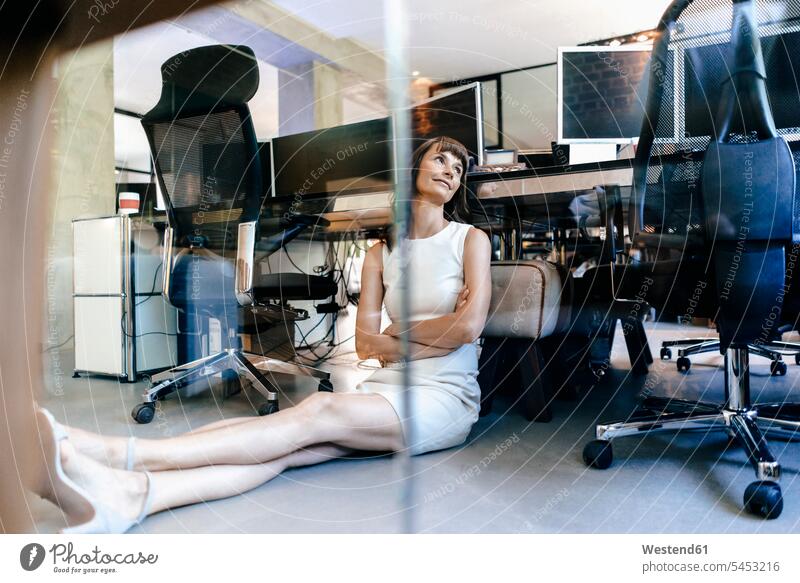 Businesswoman sitting on floor, daydreaming floors day dreaming Daydreams Day Dream Office Offices office worker businesswoman businesswomen business woman