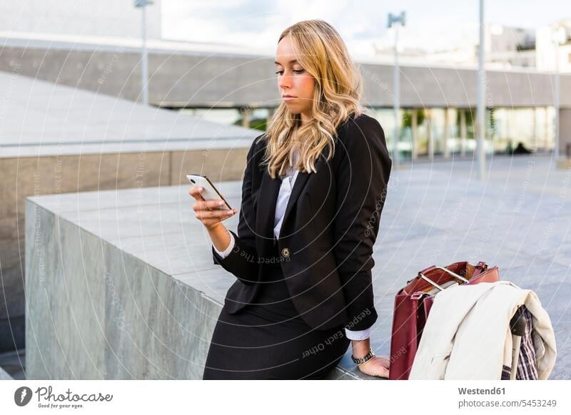 Businesswoman looking at cell phone businesswoman businesswomen business woman business women portrait portraits Smartphone iPhone Smartphones business people