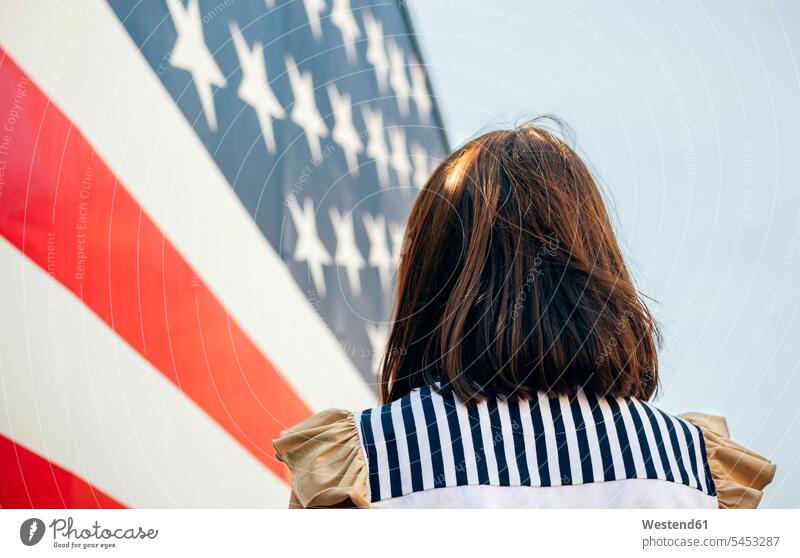 USA, back view of woman in front of Stars And Stripes national colors national colours females women Star-Spangled Banner Adults grown-ups grownups adult people