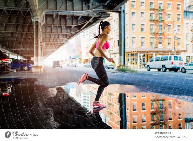Woman training in the morning in Manhattan near Brooklyn Bridge bridge bridges running exercising exercise practising fast quick speediness rapidity rapidness