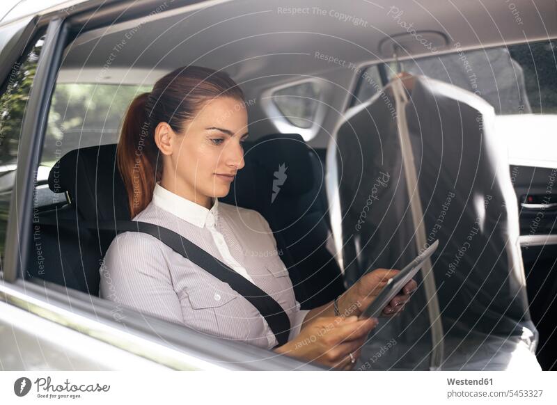 Businesswoman sitting on backseat of a car using tablet digitizer Tablet Computer Tablet PC Tablet Computers iPad Digital Tablet digital tablets automobile Auto