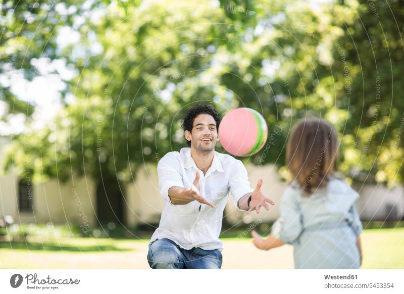 Father playing ball in garden with daughter daughters balls father pa fathers daddy dads papa child children family families people persons human being humans