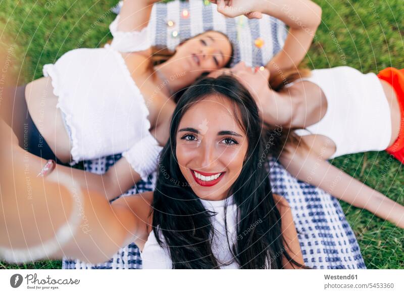 Selfie of friends in a park lying on blanket relaxed relaxation Selfies laying down lie lying down female friends parks relaxing mate friendship self-portrait