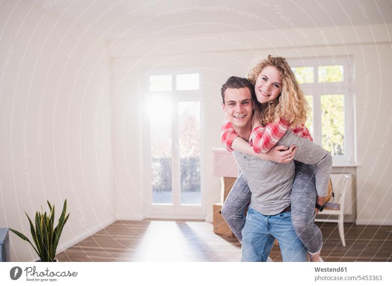 Portrait of happy young couple in new home Fun having fun funny twosomes partnership couples flat flats apartment apartments people persons human being humans