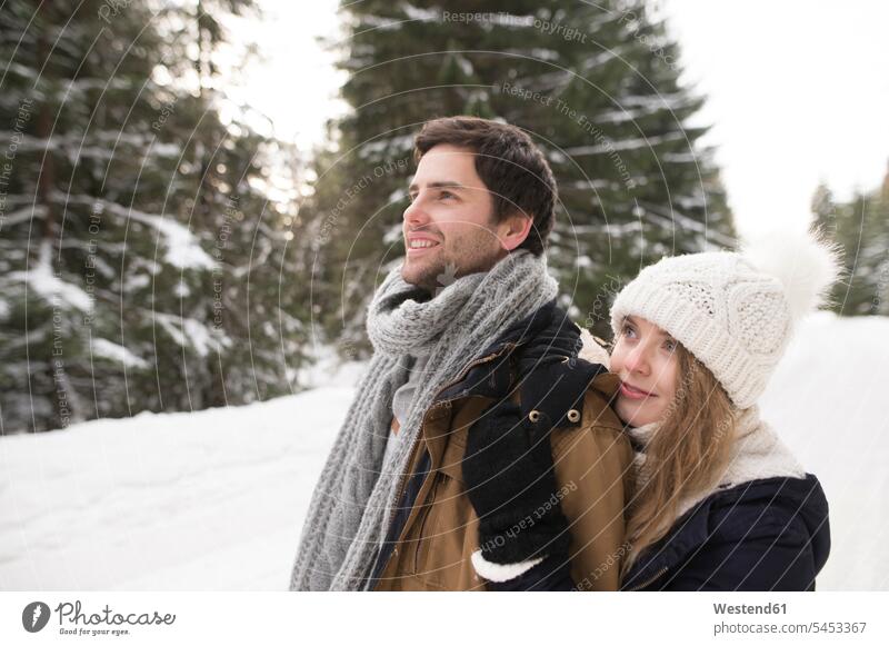 Happy young couple in snow-covered winter forest twosomes partnership couples weather people persons human being humans human beings enjoying indulgence