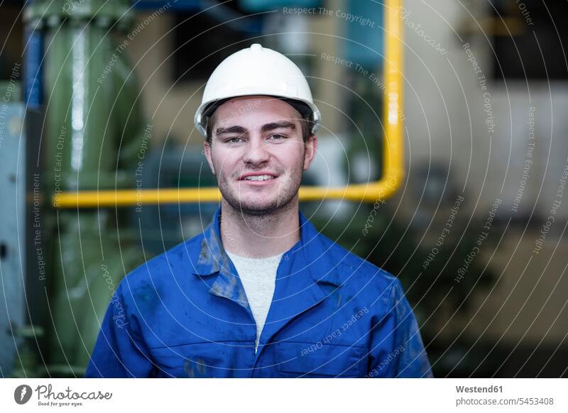 Portrait of confident worker in factory helmet helmets Protective Headwear portrait portraits smiling smile blue collar worker workers blue-collar worker Job