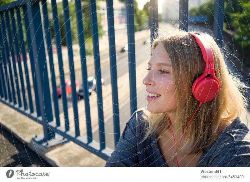 Portrait of smiling young woman listening music with headphones headset females women smile hearing portrait portraits Adults grown-ups grownups adult people