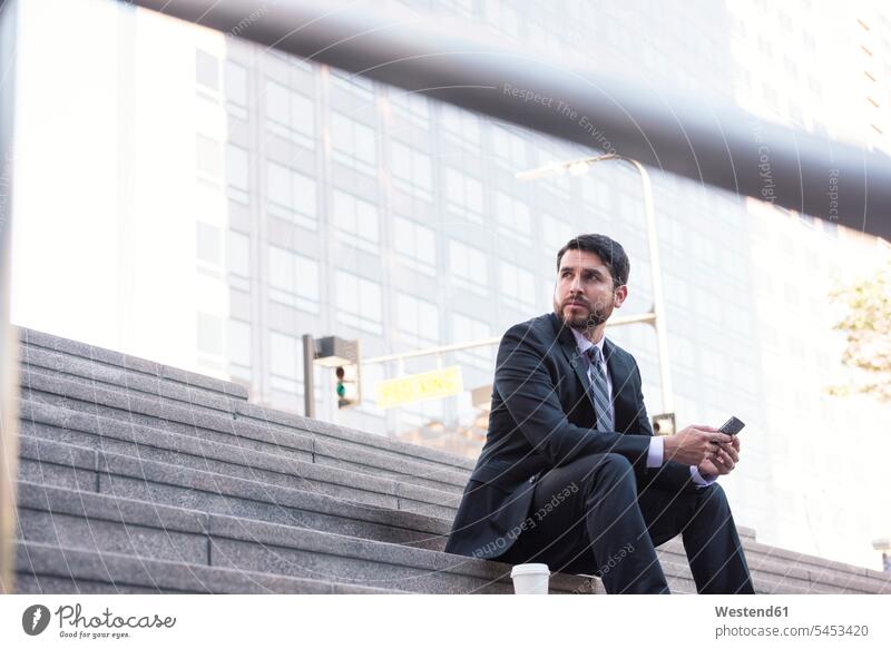 Businessman sitting on stairs with cell phone and takeaway coffee mobile phone mobiles mobile phones Cellphone cell phones break Business man Businessmen