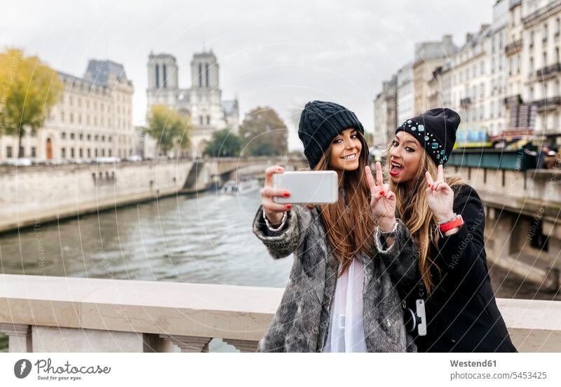 France, Paris, tourists taking selfie with cell phone photographing Selfie Selfies female friends mate friendship Smartphone iPhone Smartphones female tourist