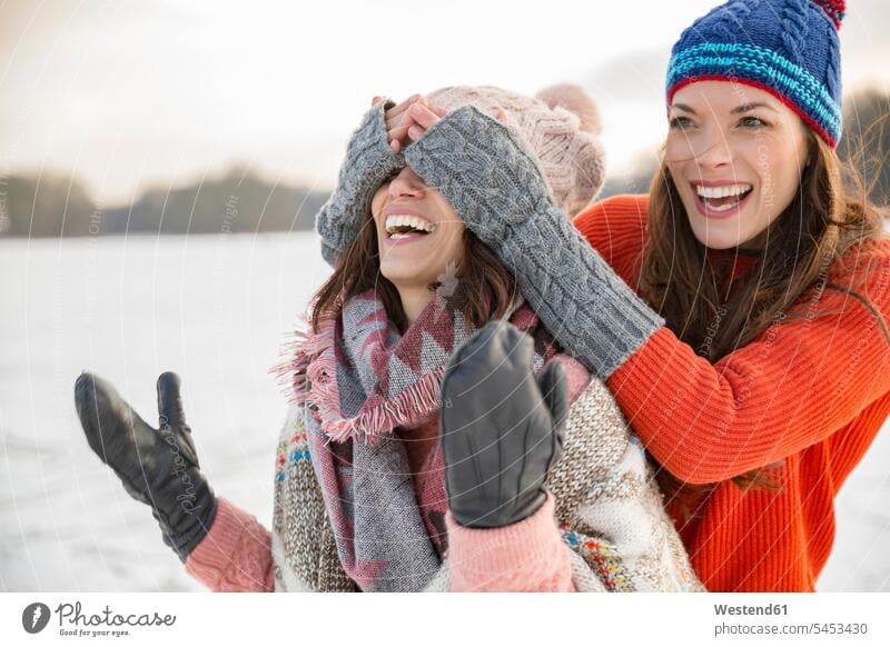 Playful friends on frozen lake Fun having fun funny woman females women female friends laughing Laughter happiness happy Adults grown-ups grownups adult people