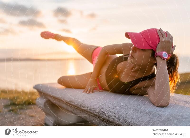 Young woman doing strength training on a bench at the sea benches warming up warm up Strength strong Force Strengthy Power side plank side planks fit exercising
