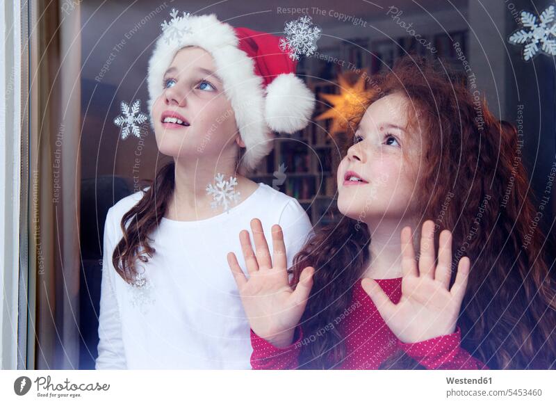 Little girls standing at the window, waiting for Christmas X-Mas yule Xmas X mas Anticipation Expectations Anticipating Anticipate hopeful expectation amazement