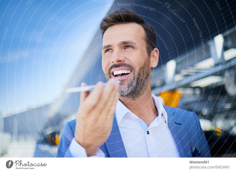 Portrait of cheerful businessman with phone in the city on the phone call telephoning On The Telephone calling Businessman Business man Businessmen Business men