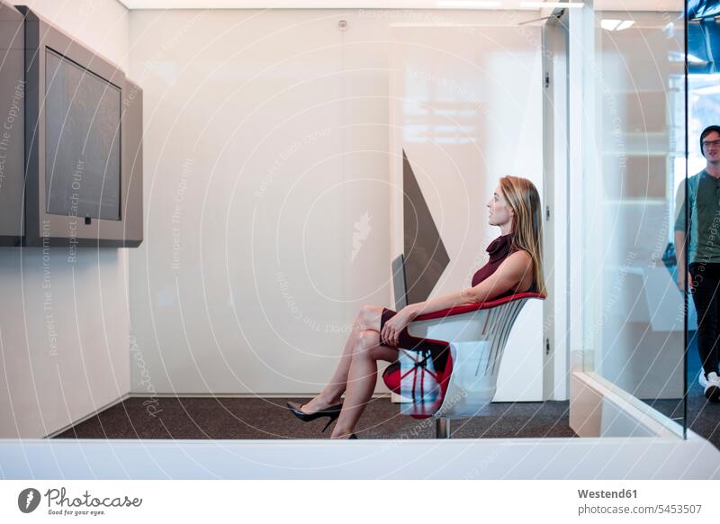 Businesswoman having a video conference in a cubicle businesswoman businesswomen business woman business women working At Work Office Offices discussing