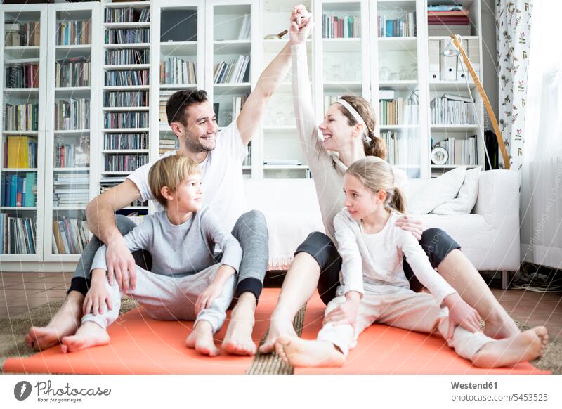 Happy family doing gymnastics at home smiling smile families fitness sportive sporting sporty athletic people persons human being humans human beings sports