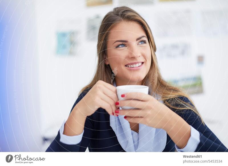 Smiling young woman having coffee break in office portrait portraits offices office room office rooms Coffee smiling smile drinking businesswoman businesswomen