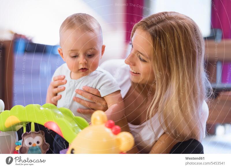 Mother and baby son playing with toys mother mommy mothers ma mummy mama sons manchild manchildren infants nurselings babies parents family families people