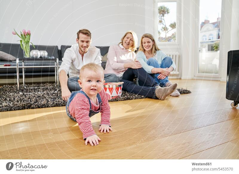 Happy familiy with baby girl in living room infants nurselings babies family families smiling smile people persons human being humans human beings grandmother