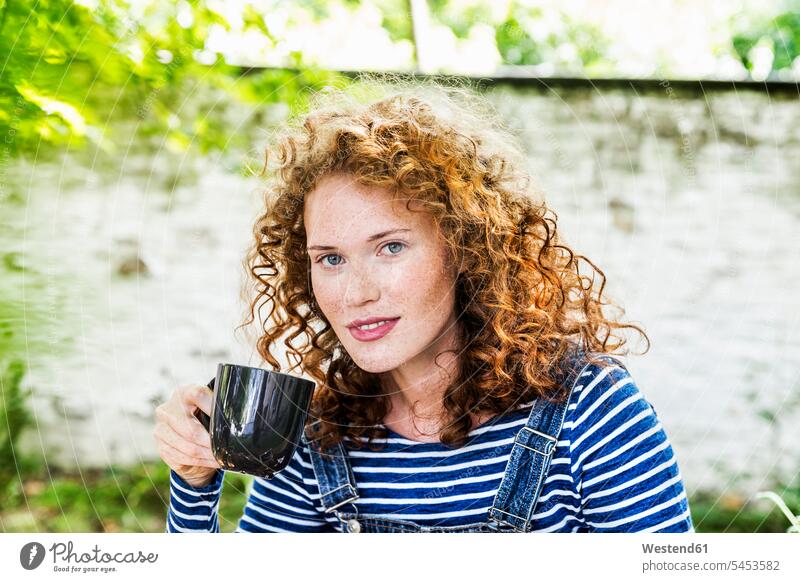 Germany, Cologne, portrait of freckled young woman with cup of coffee curly hair curls females women portraits hairstyle hair-dos hairstyles hairdos people