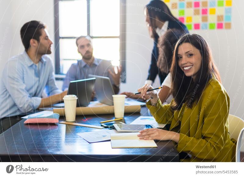 Portrait of smiling businesswoman during a meeting in office offices office room office rooms workplace work place place of work colleagues smile