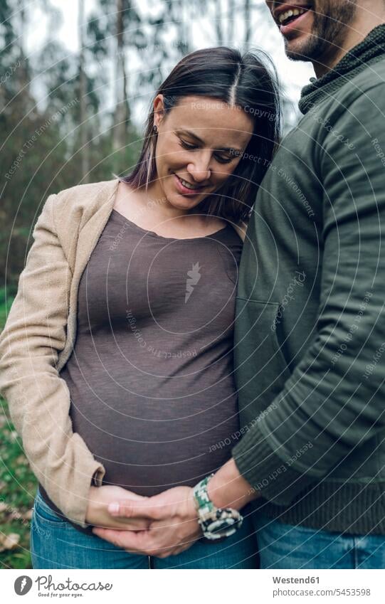 Man with smiling pregnant woman in nature couple twosomes partnership couples smile Pregnant Woman people persons human being humans human beings standing