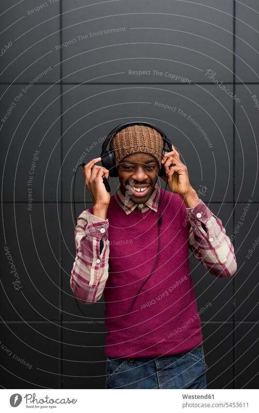 Portrait of smiling man listening music with headphones and cell phone men males headset Adults grown-ups grownups adult people persons human being humans