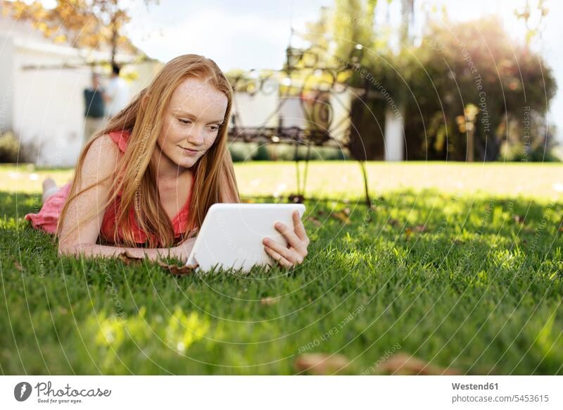 Grl with long red hair lying in grass with tablet laying down lie lying down digitizer Tablet Computer Tablet PC Tablet Computers iPad Digital Tablet