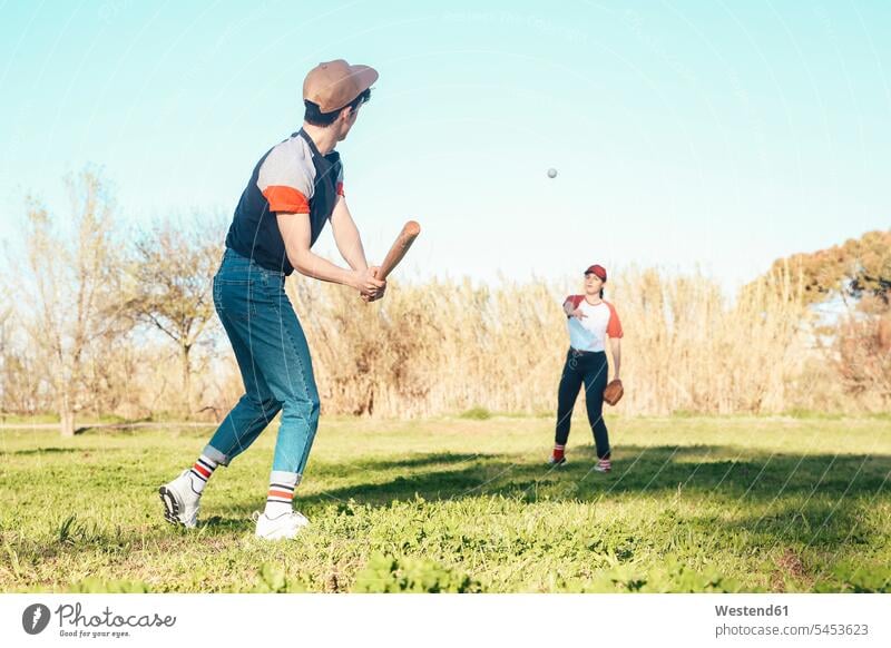 Young couple playing baseball in park twosomes partnership couples baseball player baseball players people persons human being humans human beings sport sports
