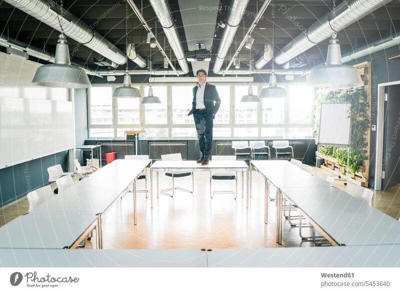Businessman standing on table in conference room office offices office room office rooms meeting room conference rooms meeting rooms Table Tables Business man