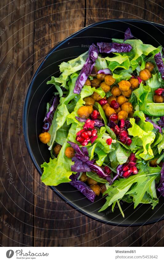 Bowl of mixed leaf salad with pomegranate seed, red cabbage and roasted curcuma chick peas food and drink Nutrition Alimentation Food and Drinks salad bowl