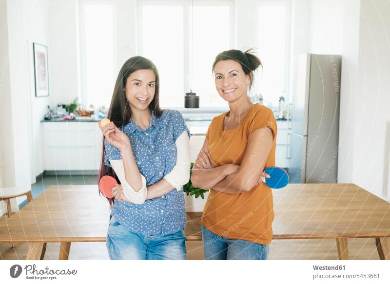 Portrait of two smiling women holding table tennis rackets at home woman females smile Table Tennis ping-pong Adults grown-ups grownups adult people persons