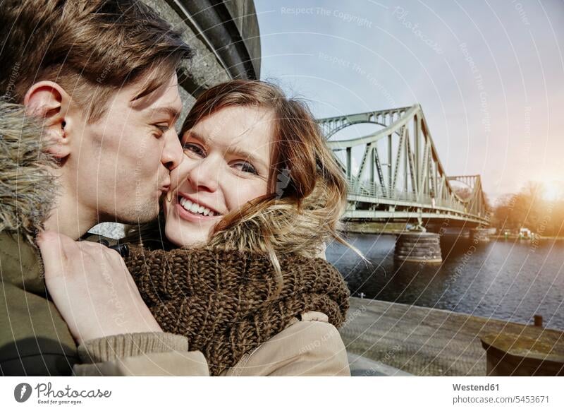 Germany, Potsdam, young couple kissing at Glienicke Bridge kisses twosomes partnership couples embracing embrace Embracement hug hugging people persons
