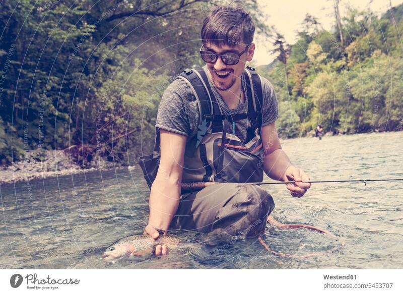 Slovenia, man fly fishing in Soca river catching a fish angling fly-fishing angler anglers Fishes men males River Rivers animal creatures animals Adults