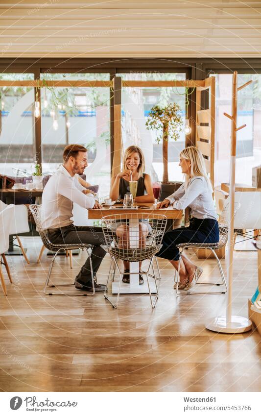 Three friends meeting in a cafe talking speaking friendship drinking Wellbeing Well-Being Well Being togetherness confidence confident lifestyle life styles
