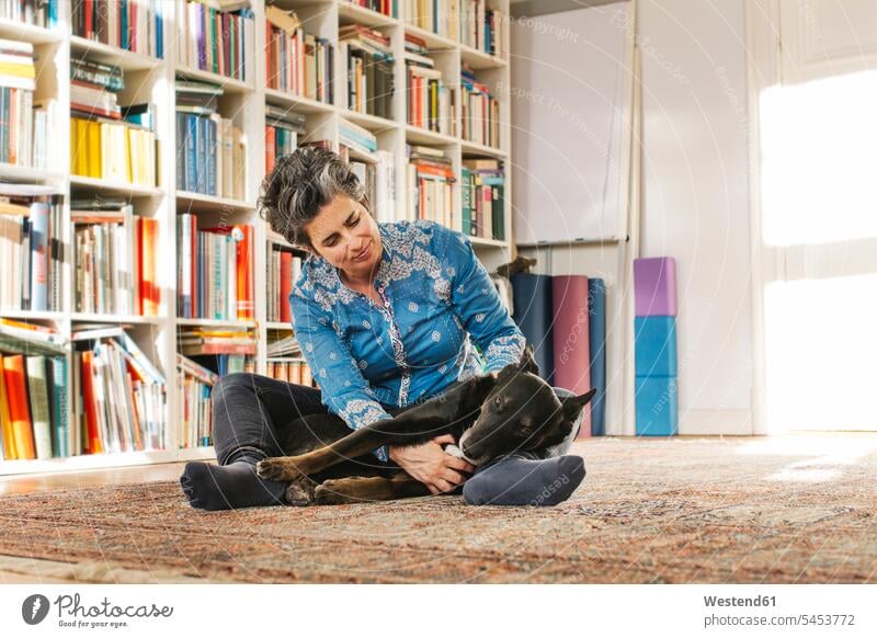 Woman with her dog on the floor at home dogs Canine woman females women pets animal creatures animals Adults grown-ups grownups adult people persons human being