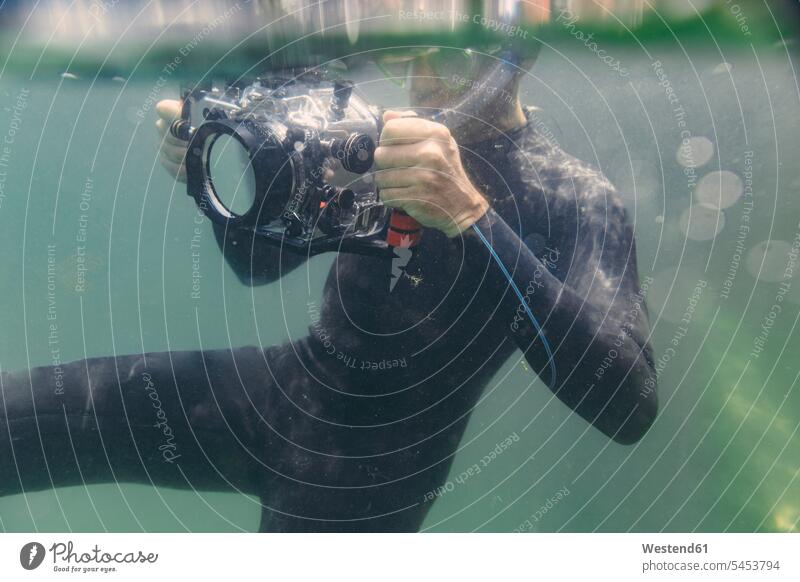 Man diving with underwater DSLR camera case dive cameras man men males diver divers Adults grown-ups grownups adult people persons human being humans