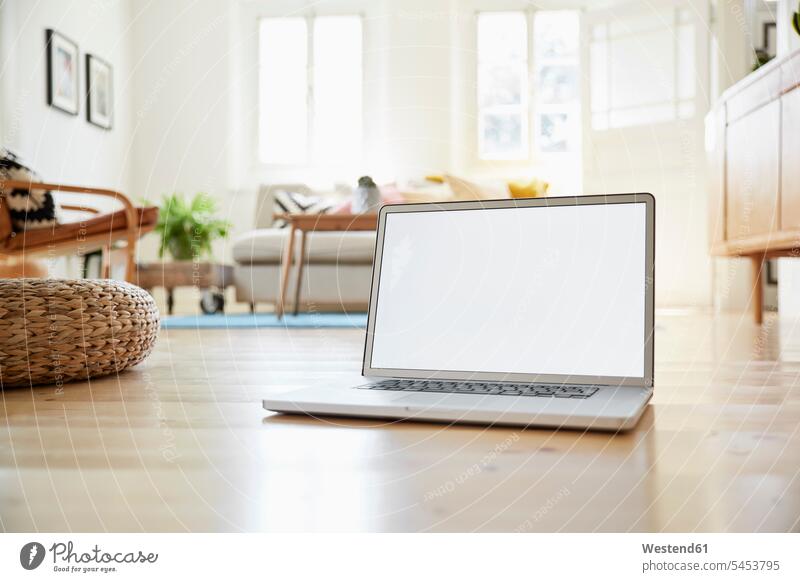 Laptop standing on wooden floor in a bright modern living room of an old country house digitization digitazing digitalisation digitalization online empty