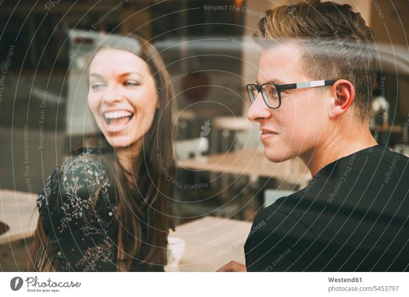 Couple sitting in a coffee shop looking through window couple twosomes partnership couples people persons human being humans human beings laughing Laughter