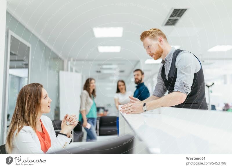 Businessman and woman discussing in office, colleagues watching together offices office room office rooms business people businesspeople workplace work place