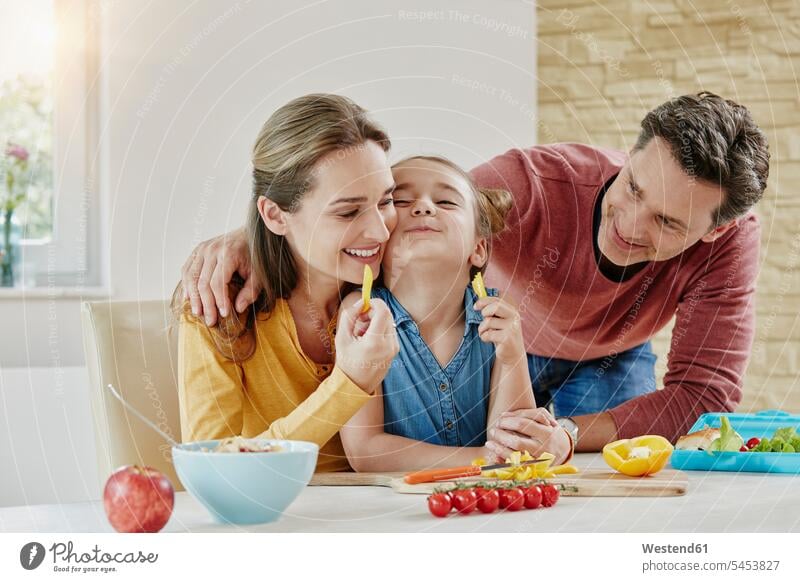 Happy family at home preparing healthy food daughter daughters families smiling smile Vegetable Vegetables happiness happy eating child children people persons