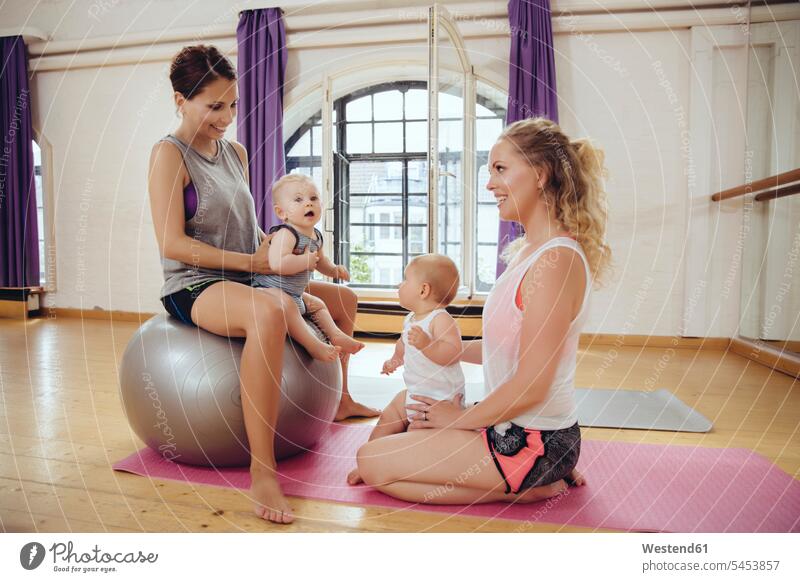 Mothers and babies in exercise room mother mommy mothers ma mummy mama baby infants nurselings smiling smile Fun having fun funny exercising training practising