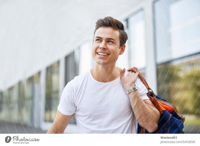 Portrait of laughing young man with sports bag men males portrait portraits Laughter Adults grown-ups grownups adult people persons human being humans