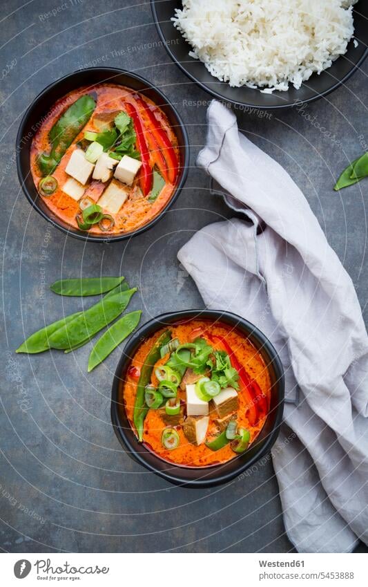 Two bowls of red Thai Curry with snow peas, carrots, bell pepper, spring onions and smoked tofu Paprika pepper vegetable capsicum Paprikas bell peppers