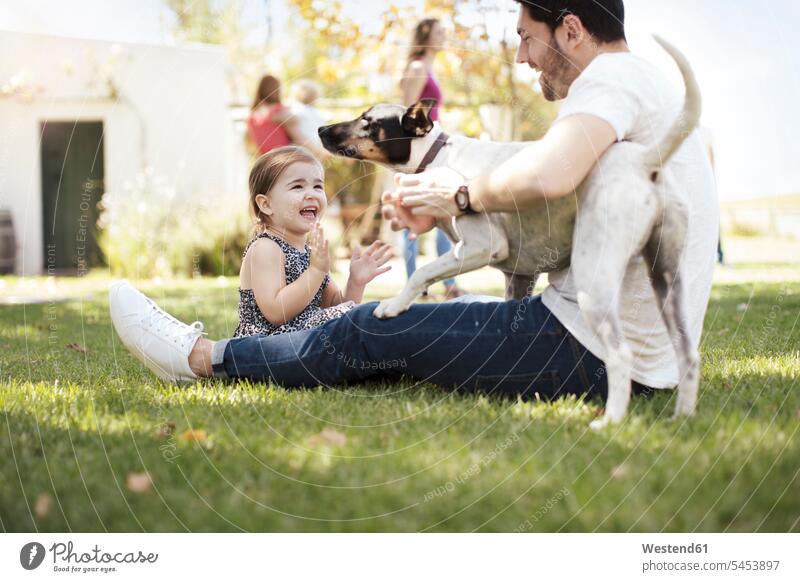 Happy father, daughter and dog in garden dogs Canine happiness happy pa fathers daddy dads papa Fun having fun funny daughters playing pets animal creatures