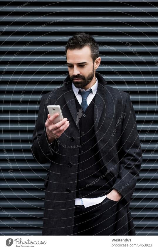 Businessman looking at cell phone mobile phone mobiles mobile phones Cellphone cell phones Business man Businessmen Business men telephones communication