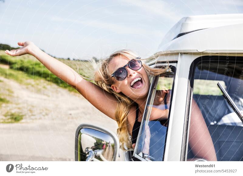 Carefree woman leaning out of window of a van Fun having fun funny laughing Laughter females women rural country countryside motor vehicle road vehicle
