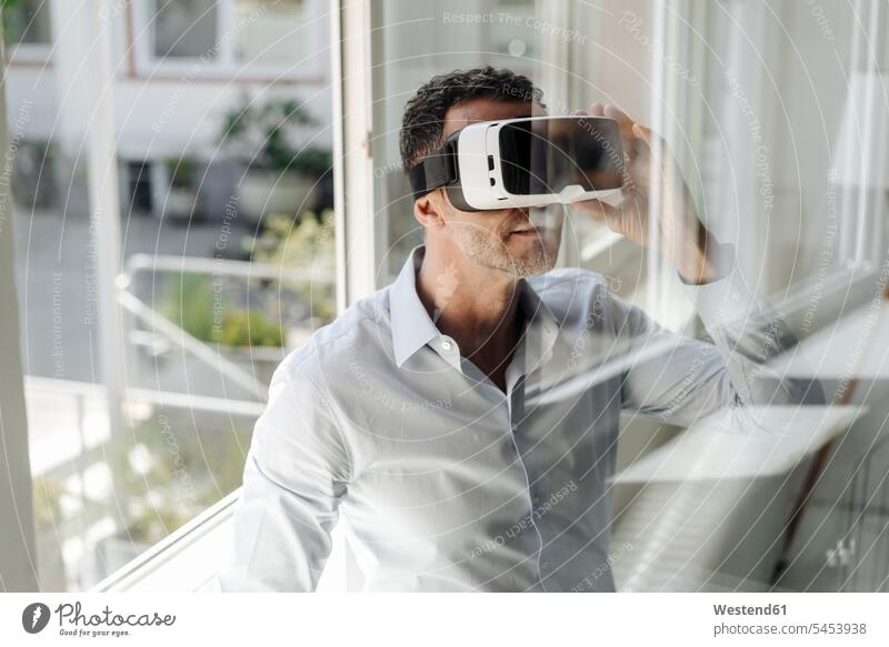 Businessman at the window wearing VR glasses office offices office room office rooms Virtual Reality Business man Businessmen Business men workplace work place